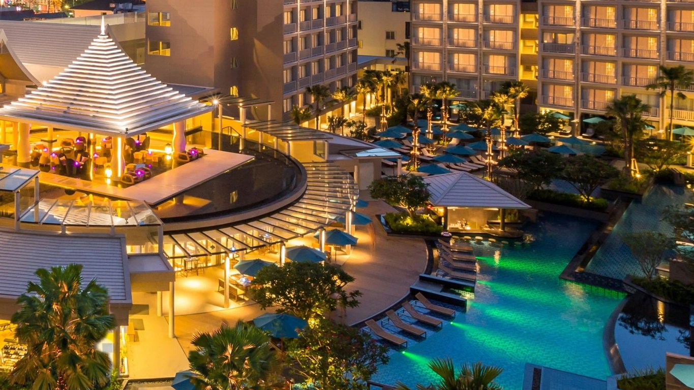 Grand Mercure Phuket Patong resort buildings and lagoon pool illuminated at dusk